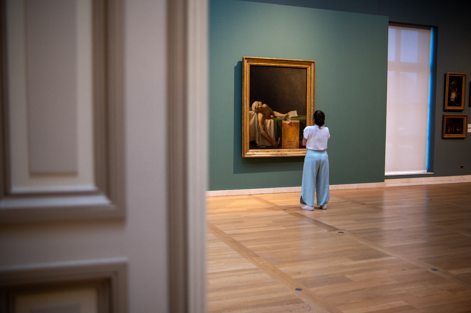 Sofia Corso observando uma pintura em uma sala de museu